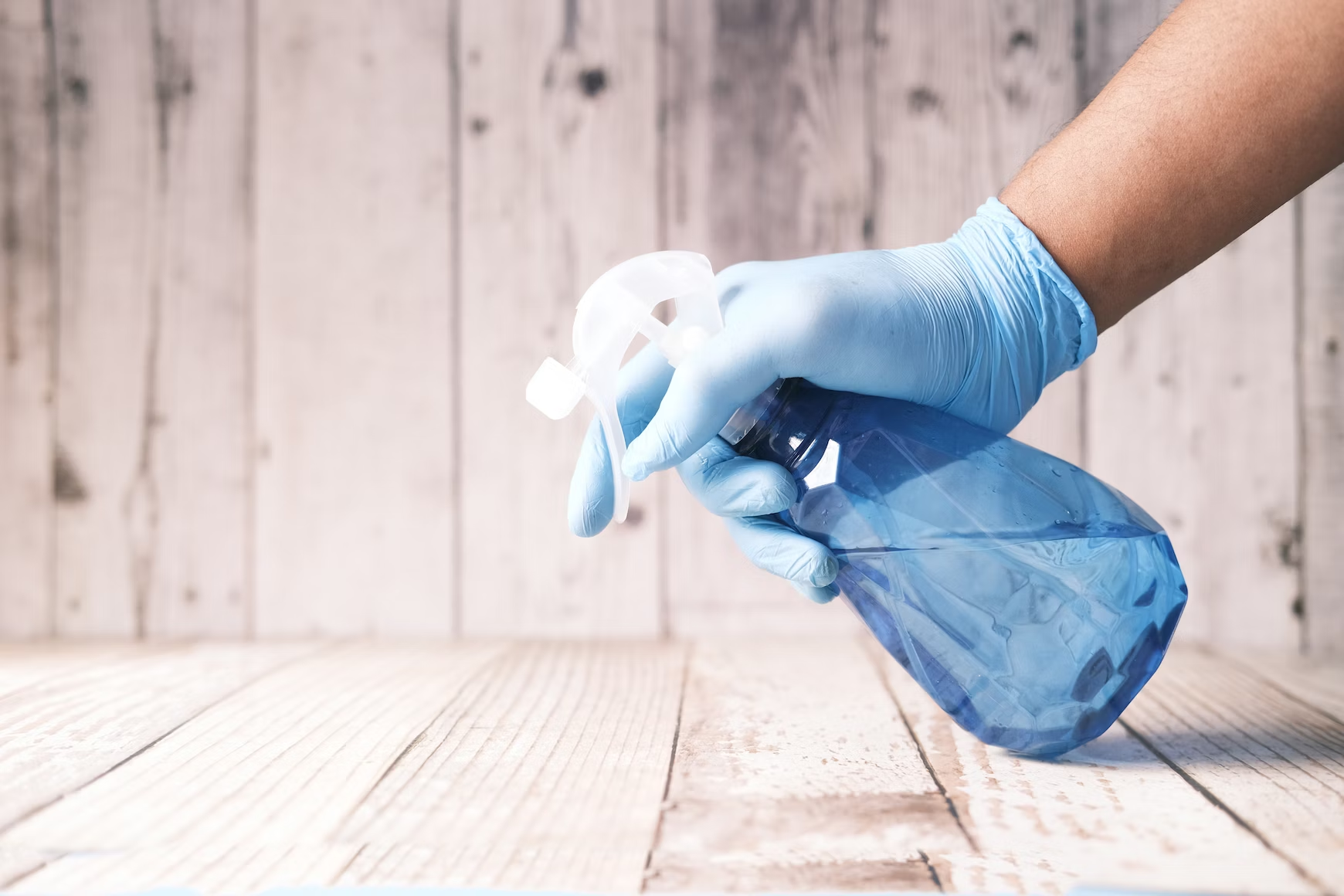 A person wears gloves while cleaning to minimize allergies and irritation.