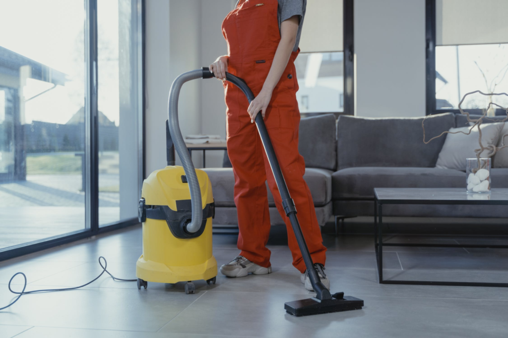 A professional cleaner uses a vacuum to clean a floor.